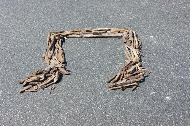 A music symbol made out of wood chips from the school parking lot.