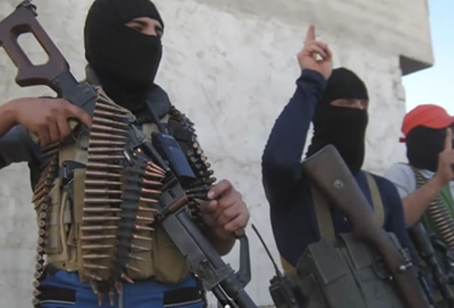 ISIS members show off their fire power, wearing masks and brandishing machineguns for a camera. 