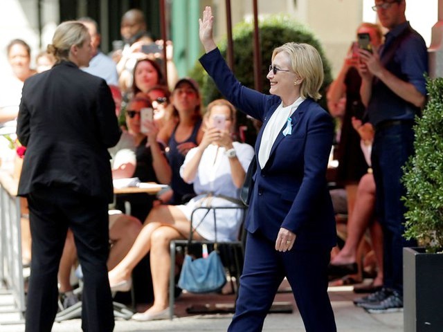 Clinton greets voters in New York City on Sunday morning, just hours before she would be escorted from the event with complaints of feeling “overheated.” She smiles widely, giving no indication to any potential health concerns. (Photo from anygator.com)