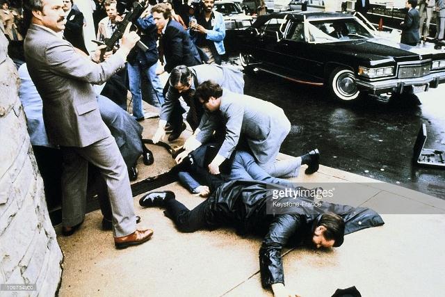 Ronald Reagan shown on the ground seconds after Hinckley fired shots. Extreme panic broke out as civilians tried to find the source of the sounds.