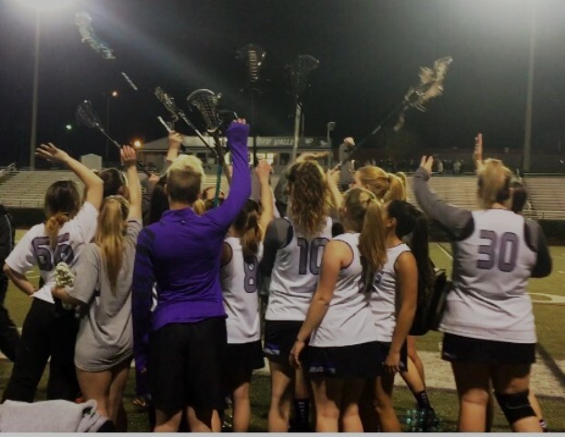 The varsity North Forsyth  girls lacrosse team huddles in to break down in a loud cheer to get excited and pumped up before the game. 