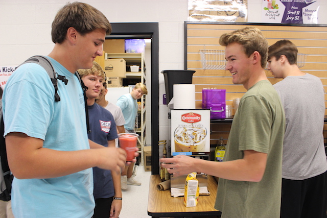 A Raider Station employee, Griffin Orzech hands a customer their fruit smoothie during the second lunch period, this hospitable practice is what makes the store so unique and well liked. The company will soon be selling products to general citizens along with the students. 