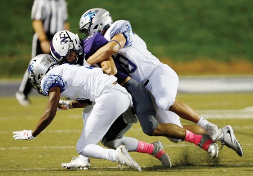 Raider running back is tackled by two South lineman at the varsity game on October 19.
