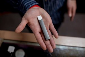 A photo of a Juul being held out. The little thing that some kids would give everything for— throwing away their relationships, health and success. Photo by Getty Images.