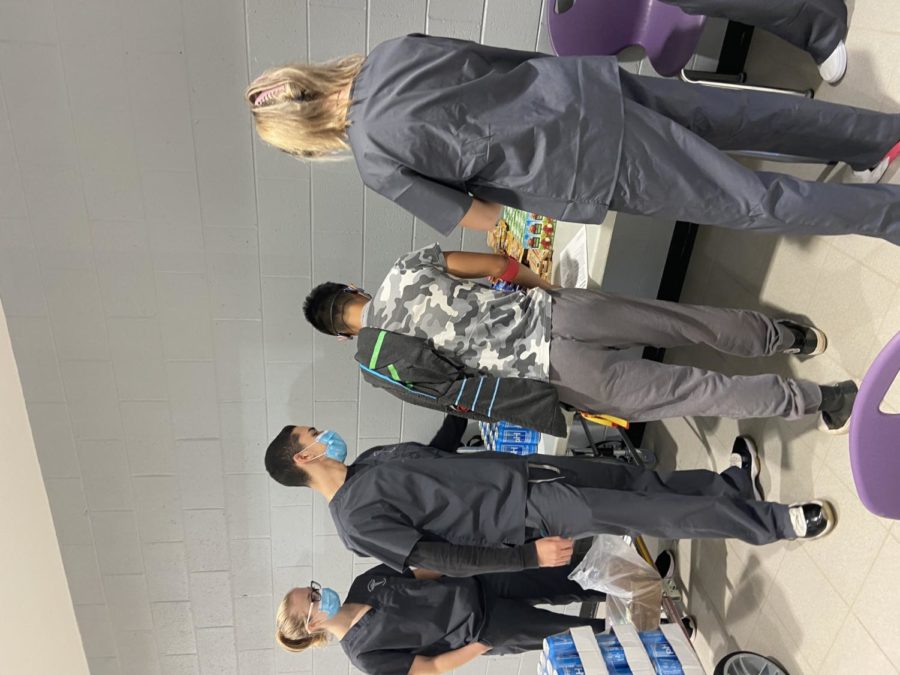 HOSA Co-President and senior Rodrigo Colon Garcia helped a donor select his post-donation snack to ensure the donor’s safety and wellbeing. Photo by Sarah Treusch.