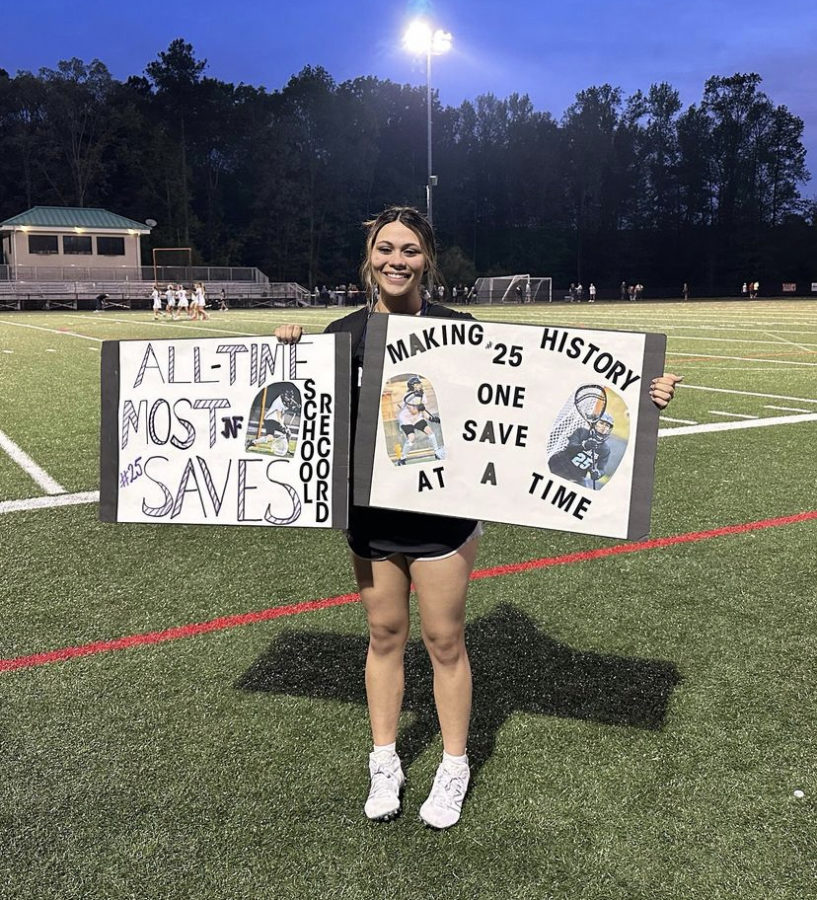 Senior Katie Musulman holding her sign for breaking the school save record.