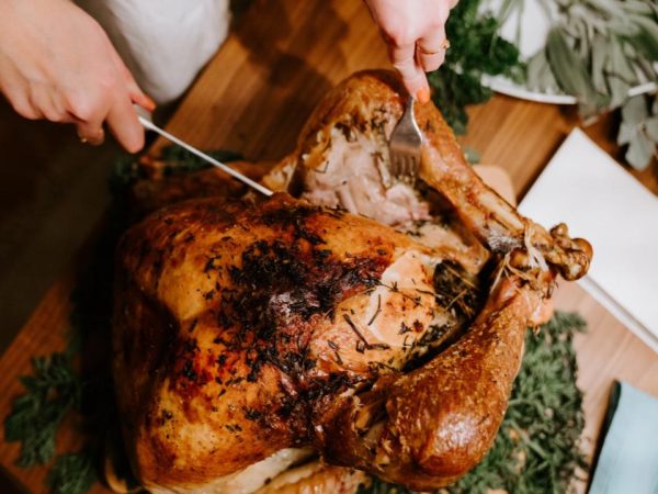 A cooked turkey being cut into, inspired by the spirit of Thanksgiving.