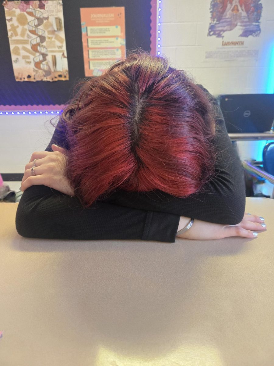 Tired student Imili Viruel with her head down on a desk.
