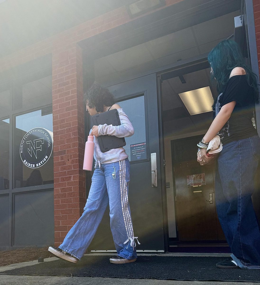 North student holding the door for one another 